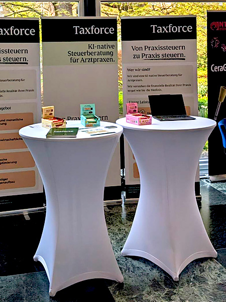 Stehtische mit weißen Hussen auf einer medizinischen Veranstaltung in Nürnberg mit Laptop und Rollups